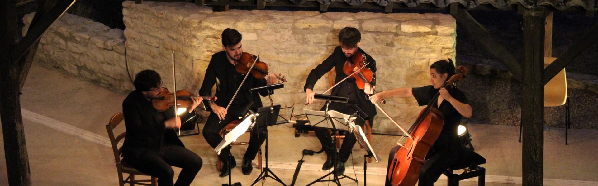 Quatre musiciens jouant de nuits sous un porche