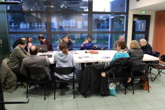 Une assemblée générale de l'association. Des personnes autour d'une table discutent des projets.