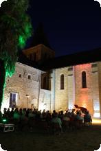 Une vue de nuit d'un concert en plein air au pied du Prieuré de Mirebeau.