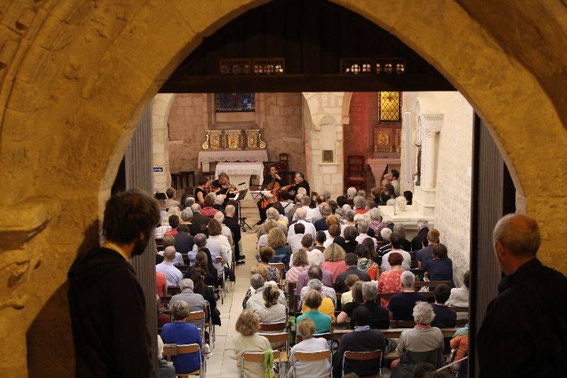 Une foule dans une église écoute un quatuor à cordes à Quinçay